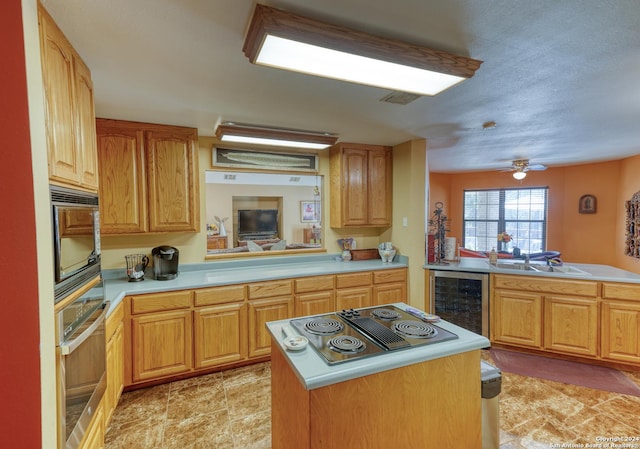 kitchen featuring sink, wine cooler, kitchen peninsula, electric stovetop, and oven