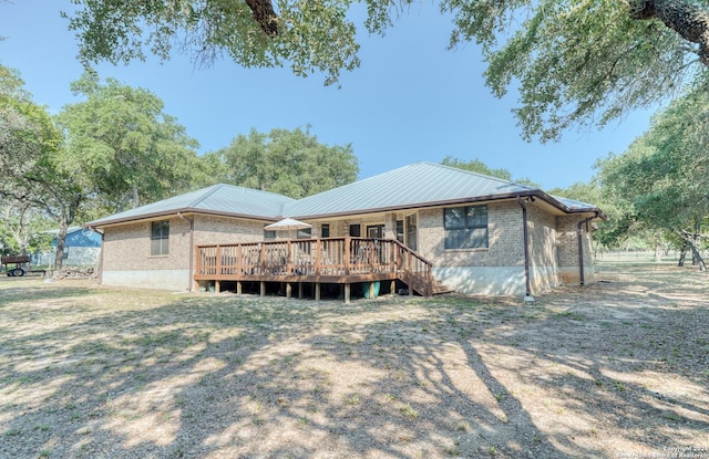 rear view of house with a deck and a lawn