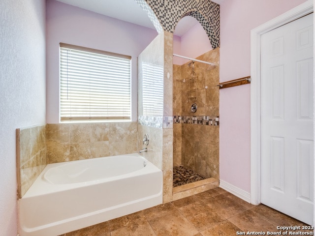 bathroom featuring tile patterned flooring and plus walk in shower