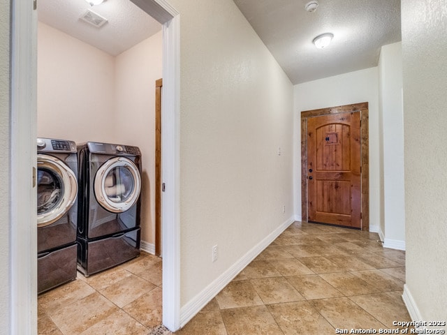 clothes washing area with independent washer and dryer and light tile patterned floors