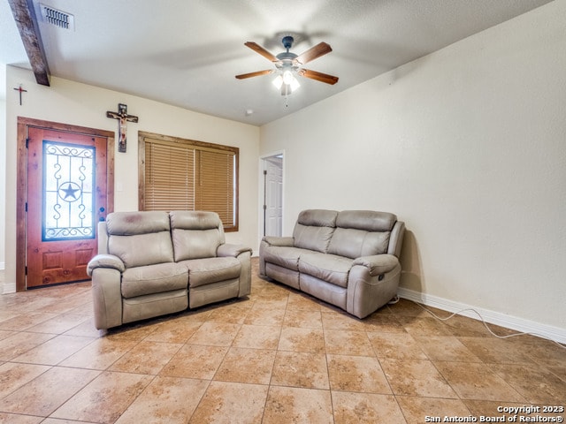 living room featuring light tile patterned flooring, beam ceiling, and ceiling fan