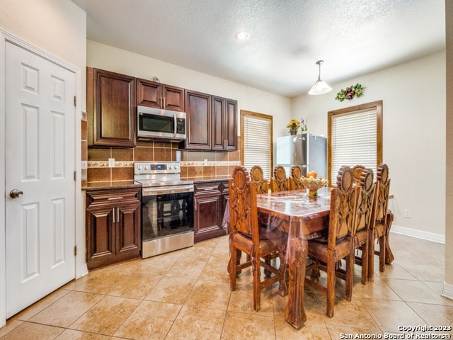 dining space with light tile patterned floors and a textured ceiling