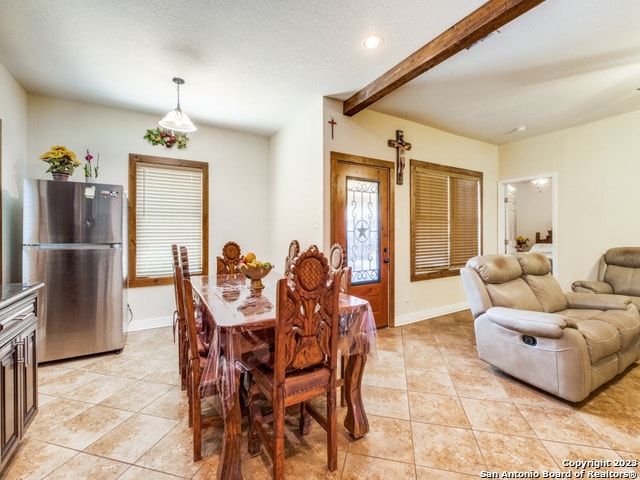 dining area featuring beamed ceiling and light tile patterned floors