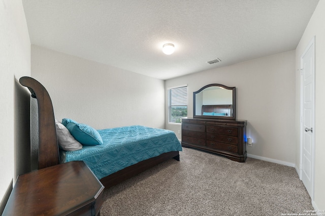 bedroom with light carpet and a textured ceiling