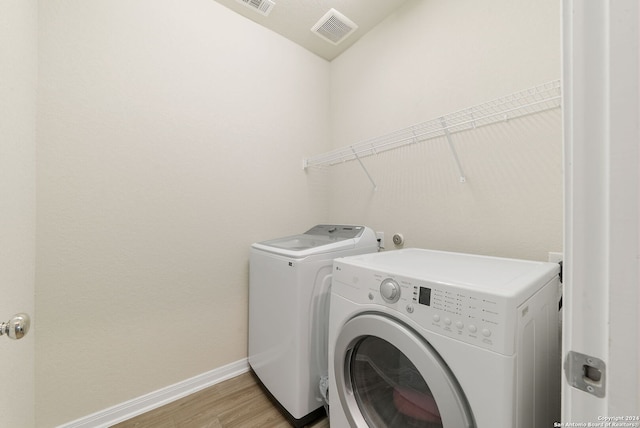 laundry area featuring separate washer and dryer and light wood-type flooring