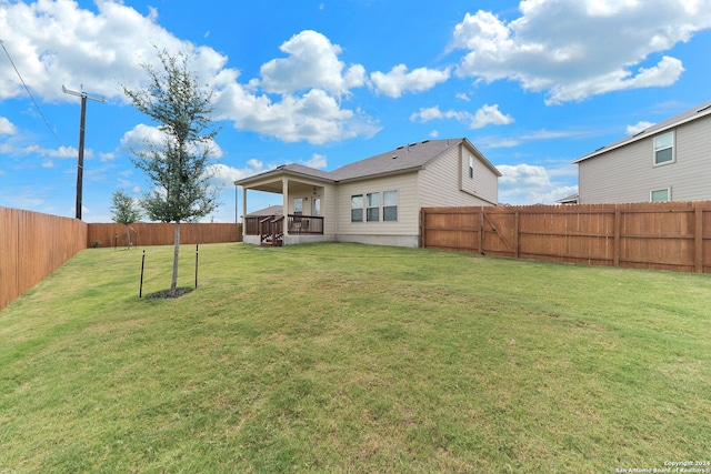 rear view of house featuring a lawn