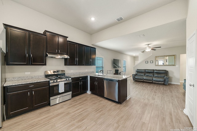 kitchen featuring sink, light wood-type flooring, kitchen peninsula, and appliances with stainless steel finishes