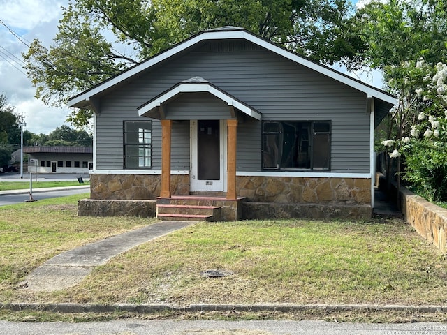 bungalow-style home featuring a garage and a front lawn