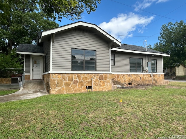 view of front facade featuring central air condition unit and a front lawn