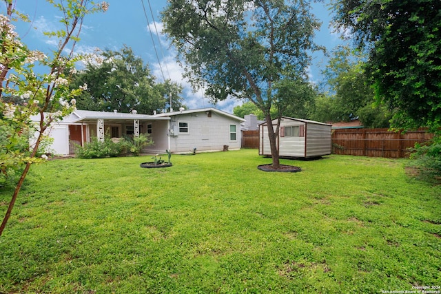 rear view of property with a yard and a storage unit