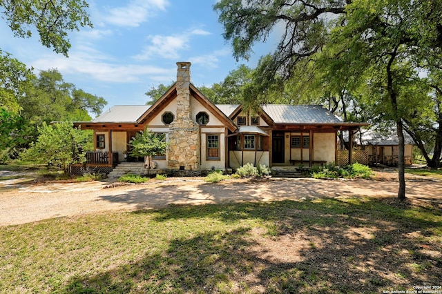 tudor-style house with a front yard and covered porch