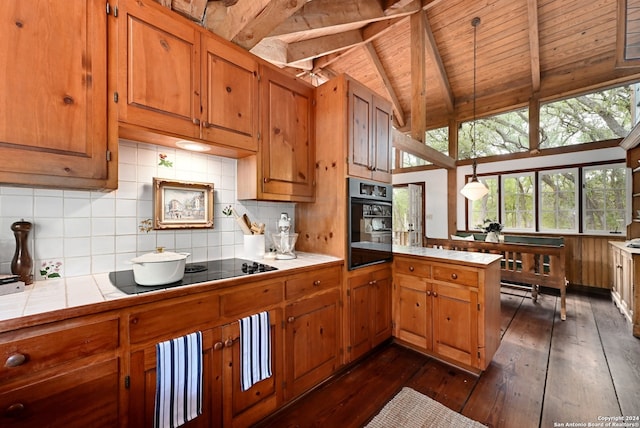 kitchen featuring beamed ceiling, dark hardwood / wood-style floors, tile counters, and black appliances