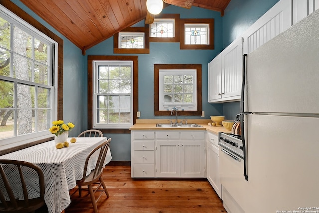 kitchen featuring lofted ceiling, sink, white refrigerator, range with gas stovetop, and white cabinets