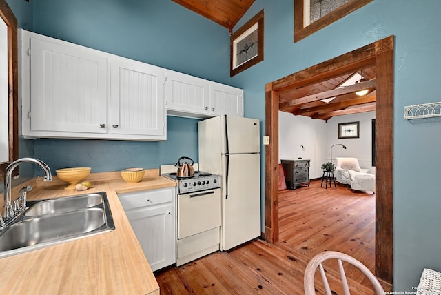 kitchen featuring sink, vaulted ceiling with beams, white cabinets, wooden ceiling, and white appliances