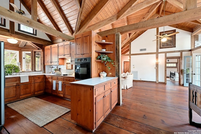 kitchen featuring beamed ceiling, dark hardwood / wood-style floors, black oven, and decorative backsplash