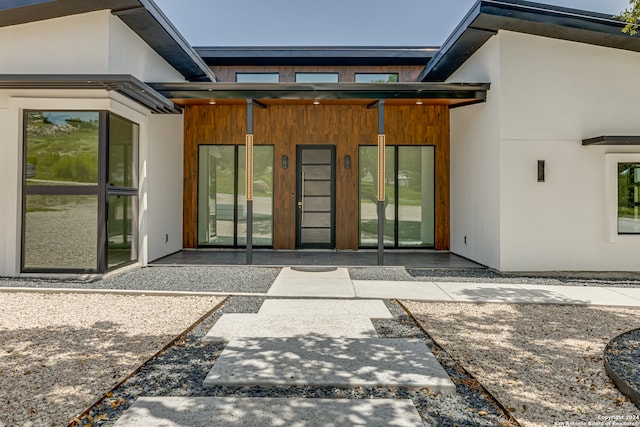 view of exterior entry with a patio