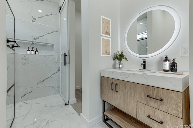 bathroom with tiled shower, vanity, and tile patterned flooring