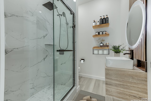 bathroom with sink, toilet, a shower with door, and wood-type flooring