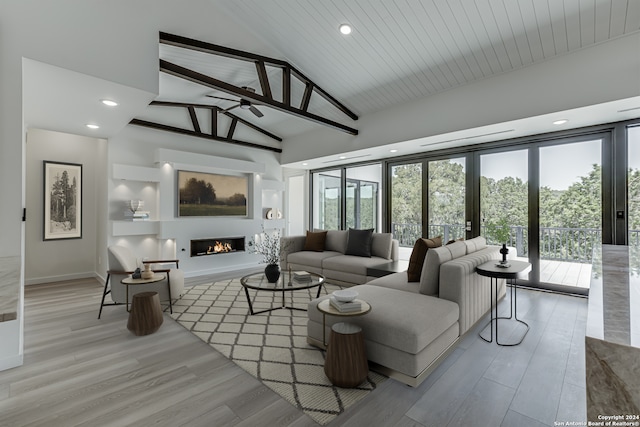 living room with high vaulted ceiling, ceiling fan, light hardwood / wood-style floors, and beam ceiling