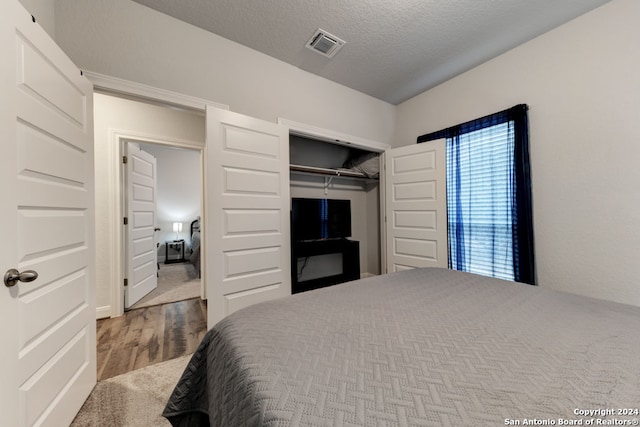 bedroom featuring a textured ceiling, a closet, and carpet flooring