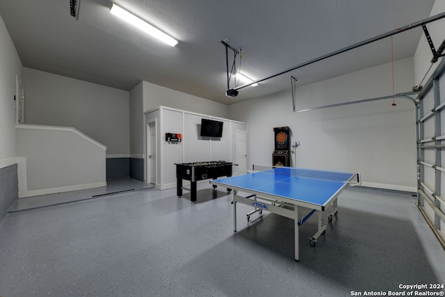 recreation room with a textured ceiling