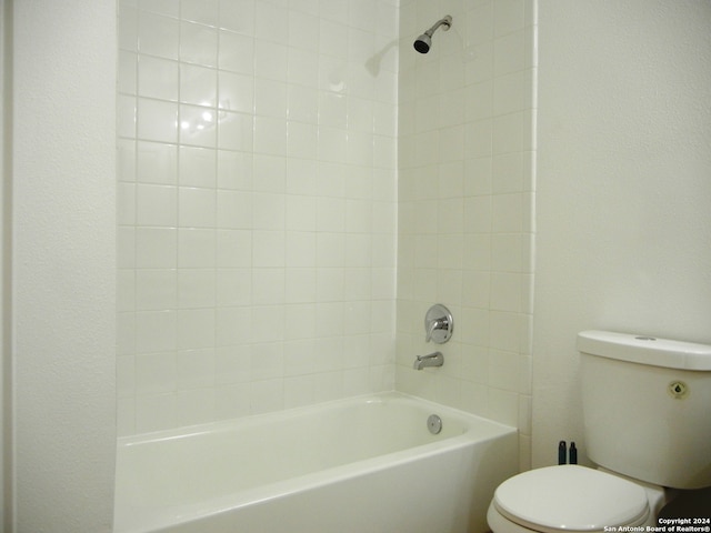 bathroom with toilet and tiled shower / bath