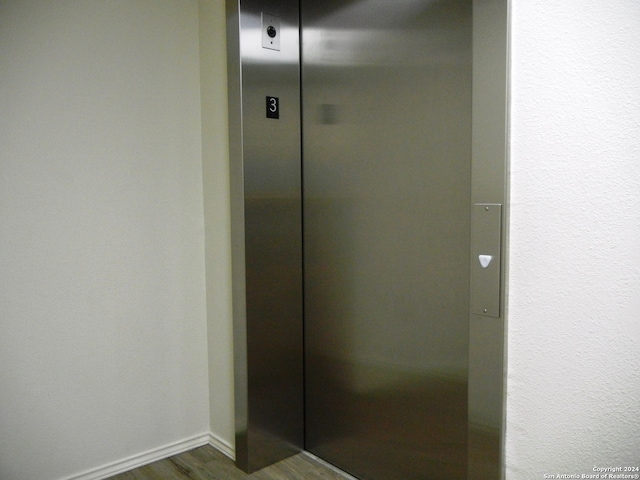 bathroom with elevator and wood-type flooring