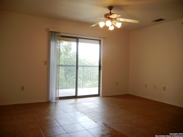 tiled empty room featuring ceiling fan