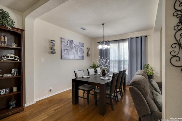 dining room featuring dark hardwood / wood-style floors and an inviting chandelier