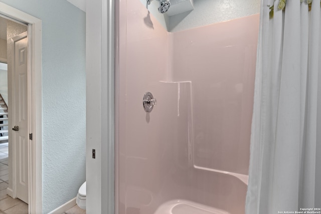 bathroom featuring toilet and tile patterned flooring