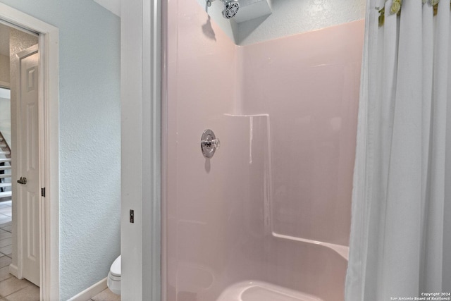 696 Faurie Rd, Lakehills, TX 78063 - bathroom with a stall shower, toilet, a textured wall, and tile patterned flooring