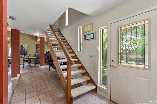 tiled foyer entrance with a textured ceiling