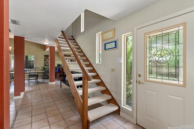 696 Faurie Rd, Lakehills, TX 78063 - entrance foyer featuring stairway, light tile patterned floors, and baseboards