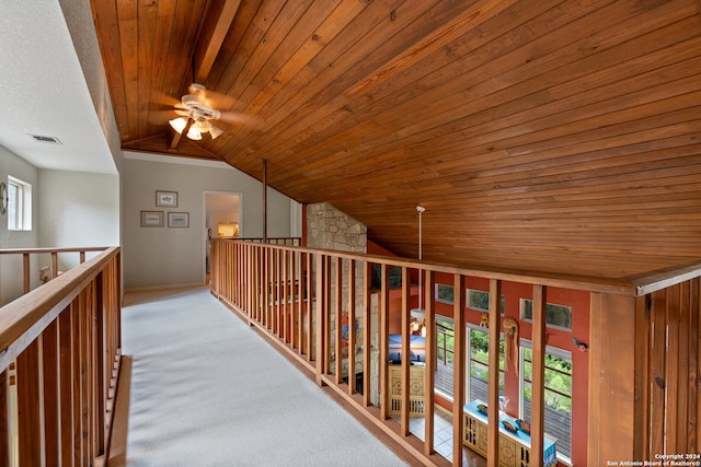 hall with carpet floors, wooden ceiling, and vaulted ceiling