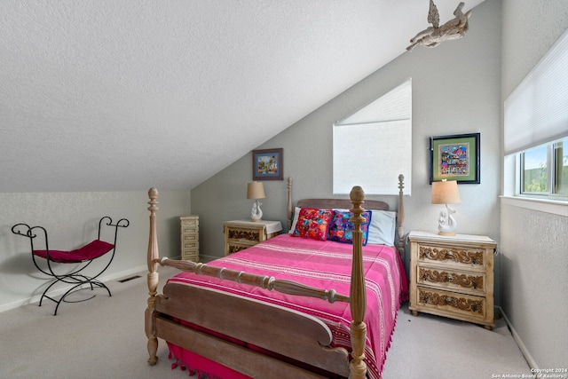 bedroom featuring a textured ceiling, carpet, and lofted ceiling