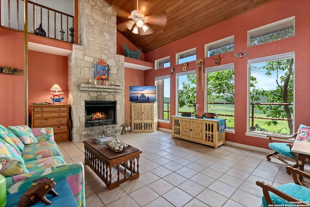 696 Faurie Rd, Lakehills, TX 78063 - tiled living area featuring wooden ceiling, high vaulted ceiling, a ceiling fan, healthy amount of natural light, and a stone fireplace
