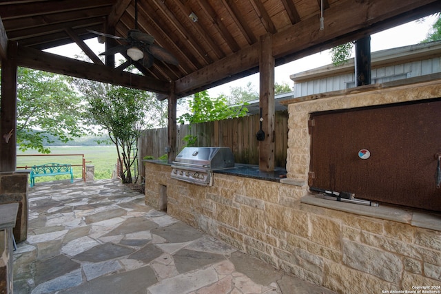 view of patio with area for grilling, ceiling fan, and a grill