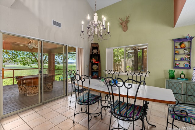 dining area featuring an inviting chandelier, light tile patterned floors, and high vaulted ceiling