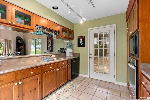 696 Faurie Rd, Lakehills, TX 78063 - kitchen featuring black appliances, a sink, brown cabinets, glass insert cabinets, and light tile patterned floors