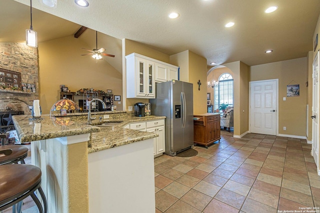 217 Meadowlark Ln, Mcqueeney, TX 78123 - kitchen with decorative light fixtures, white cabinetry, stainless steel fridge, a kitchen bar, and kitchen peninsula