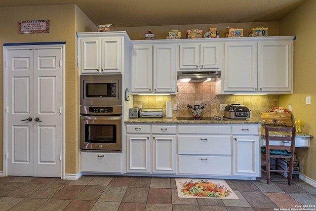 217 Meadowlark Ln, Mcqueeney, TX 78123 - kitchen with appliances with stainless steel finishes, dark tile patterned flooring, and white cabinets