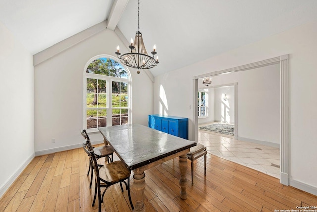 dining area with beamed ceiling, high vaulted ceiling, a chandelier, and light wood-type flooring