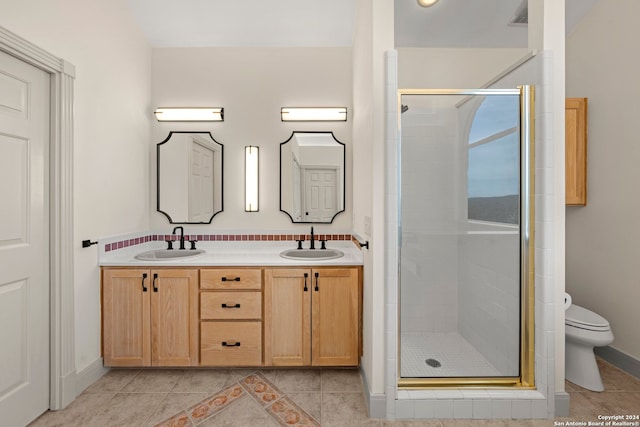 bathroom with tile patterned flooring, a shower with shower door, toilet, and dual bowl vanity