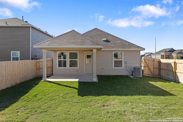 rear view of property with a yard, central AC unit, and a patio