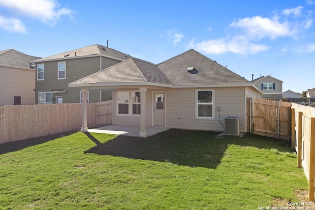 rear view of house with a patio, a yard, and central AC unit