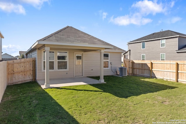 rear view of house with central AC, a yard, and a patio area