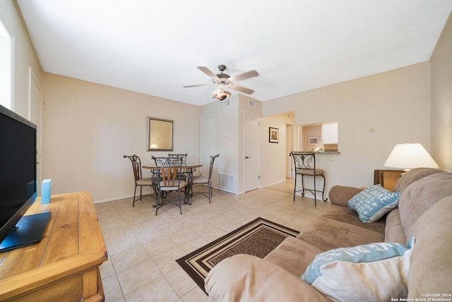 living area featuring light tile patterned floors, baseboards, a ceiling fan, and visible vents