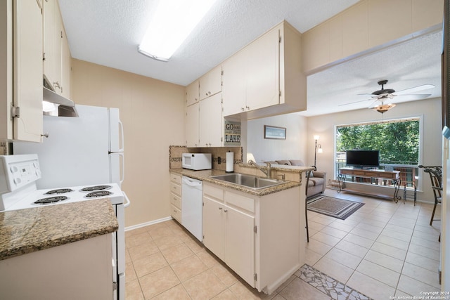 kitchen featuring white appliances, open floor plan, a ceiling fan, under cabinet range hood, and a sink