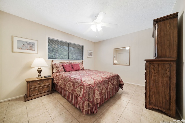 bedroom with light tile patterned floors, ceiling fan, baseboards, and a textured ceiling
