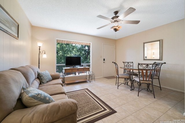 living room featuring light tile patterned floors, a textured ceiling, and a ceiling fan